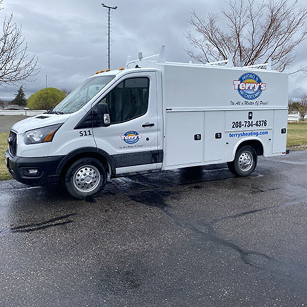 Air Conditioning Install 1_600x600 Terry’s Heating & Air Conditioning service van parked on a residential street, ready for air conditioning installation. Company branding and contact information are clearly visible on the vehicle.