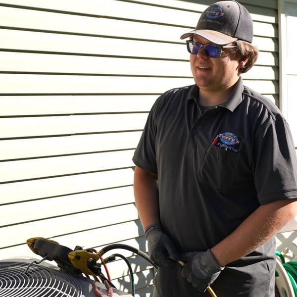 Terry’s Employee next to an outdoor AC unit testing the output of a customers unit.