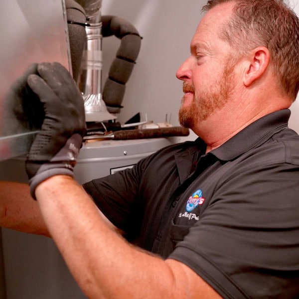 Terry’s employee wearing grey branded shirt working on replacing air handler in customers laundry room.