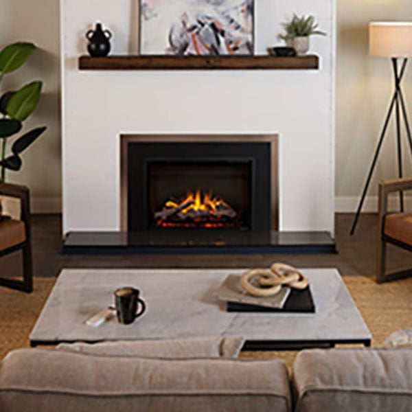 A cozy living room featuring an electric fireplace and two comfortable chairs arranged for relaxation.