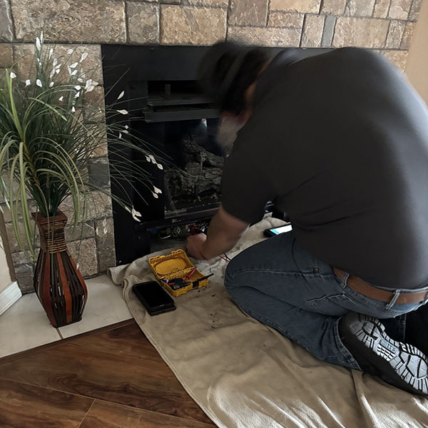 Technician removing ash and debris from fireplace during maintenance