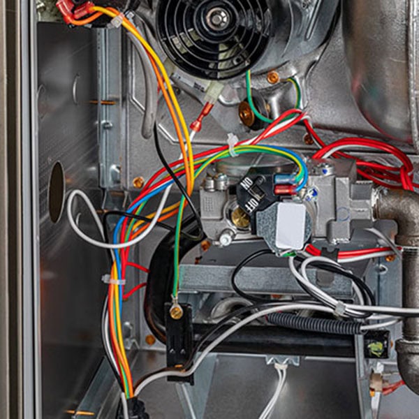 Close-up of a gas furnace showing wires, highlighting details relevant to gas furnace repair.