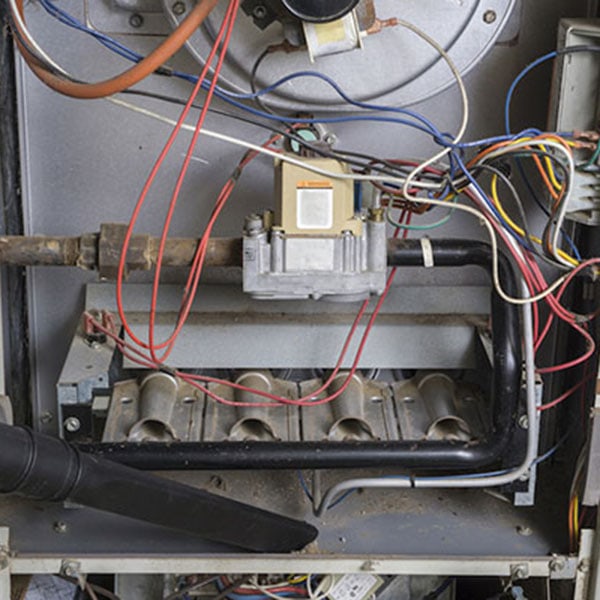 A gas furnace displaying various wires and electrical components for heating system functionality.