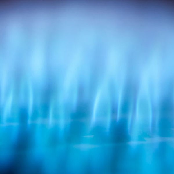 Blue flames of a gas burner, illustrating the efficient heat source for cooking on gas stoves and inserts.