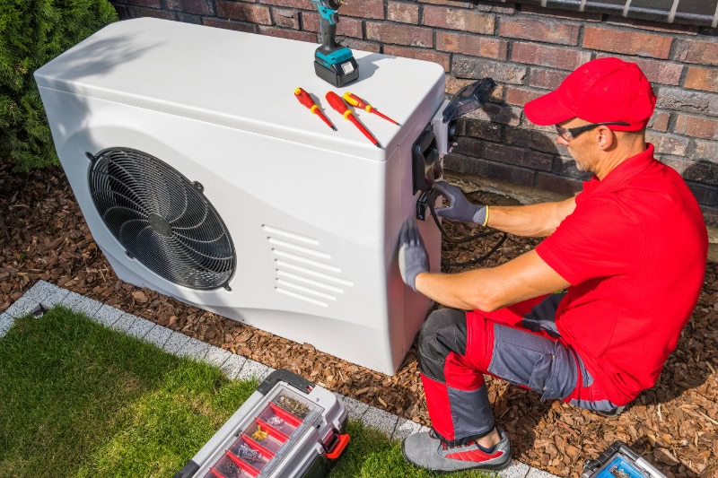 Technician repairing heat pump unit.
