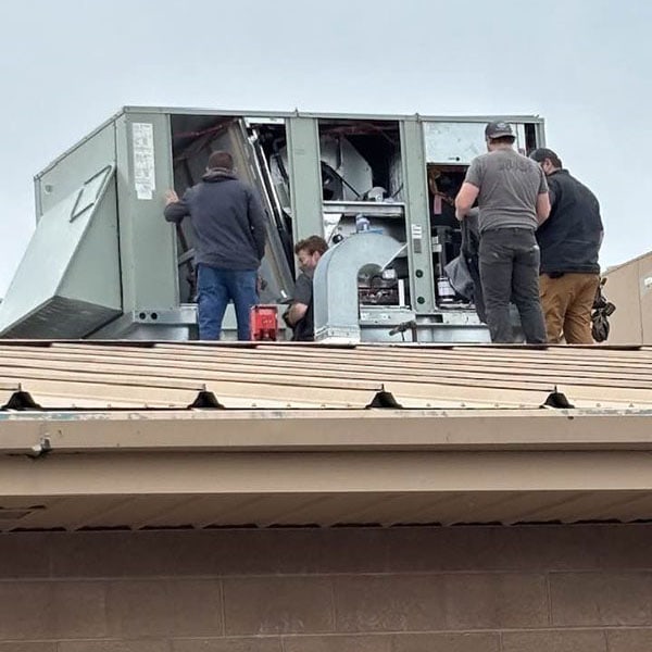 Terry’s employees on a roof providing maintenance to an AC Unit.